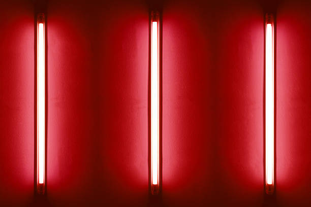 istock Three red neon bulbs on white wall. Background texture of empty old wall with glowing red neon bulbs. 1807784086