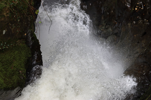 Close up of spray from a large waterfall in a rocky ravine