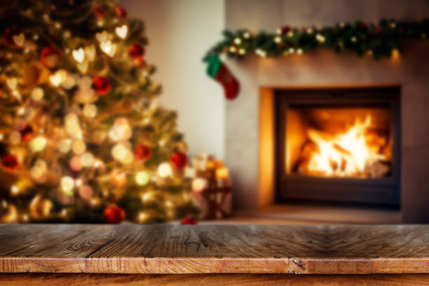 istock Wooden table with blurred Christmas tree and fireplace background. 1807796261