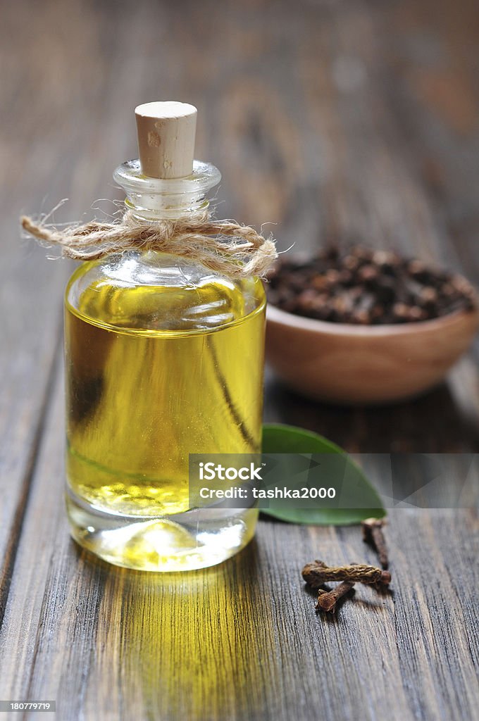 Oil of cloves Oil of cloves in a glass bottle over wooden background Aromatherapy Stock Photo