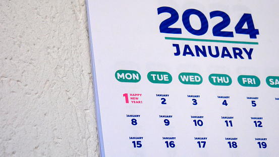 Close-up of a wall calendar January page and New Years date 2024 marked on it