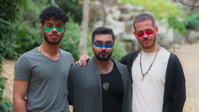 Portrait of group men friends with their faces painted standing side by side in nature