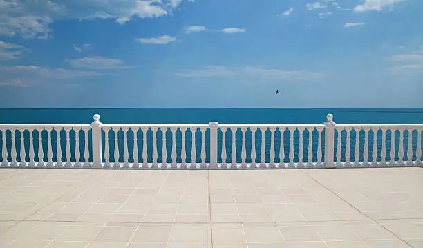 Summer view with classic white balustrade and empty terrace overlooking the sea (Italy)