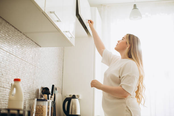 istock Young smiling woman in the kitchen, making breakfast from cereal and milk. 1807823385