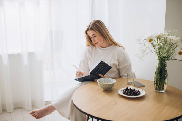 istock Young beautiful female student at home doing creative journal. 1807824044