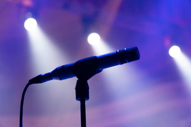 istock Microphone on stage against the background of spotlights 1807834951