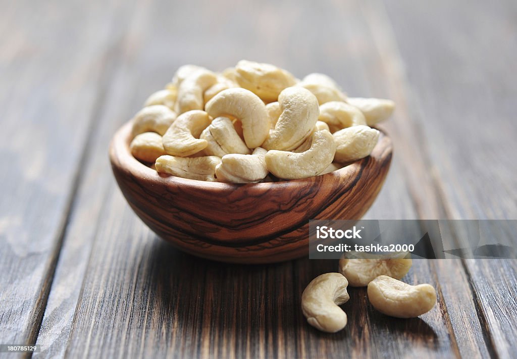 Roasted cashews Roasted cashews on natural wooden table background Appetizer Stock Photo