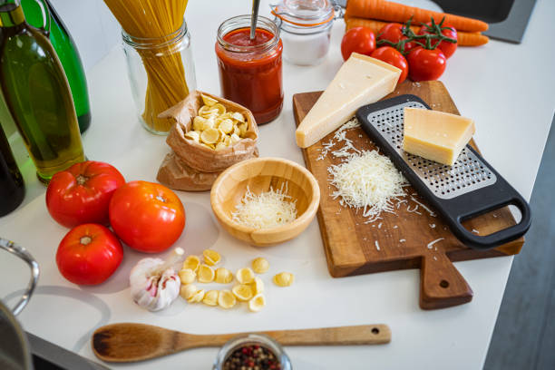 istock Grated Parmesan cheese and ingredients for cooking pasta on kitchen counter 1807890451