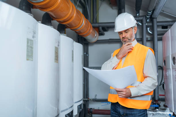 istock Experienced engineer serviceman trying to detect the problem inside power plant. old man with blueprints working in a factory 1807903471