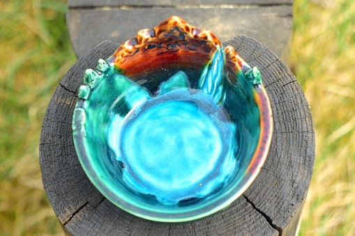 A saucer made of clay, covered with multicolored glaze. Handmade work.