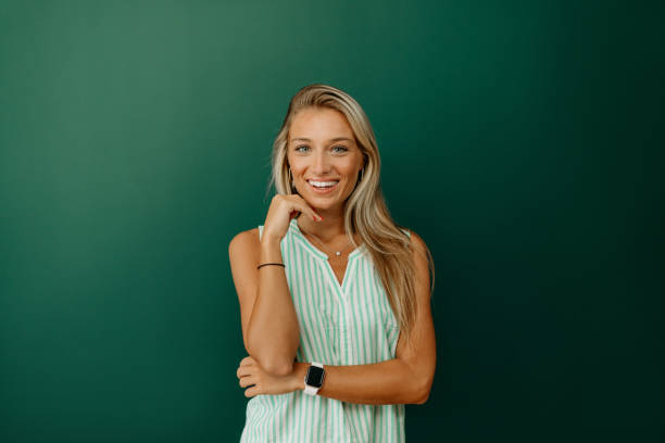 istock Beautiful woman looking at camera on green background 1807907528