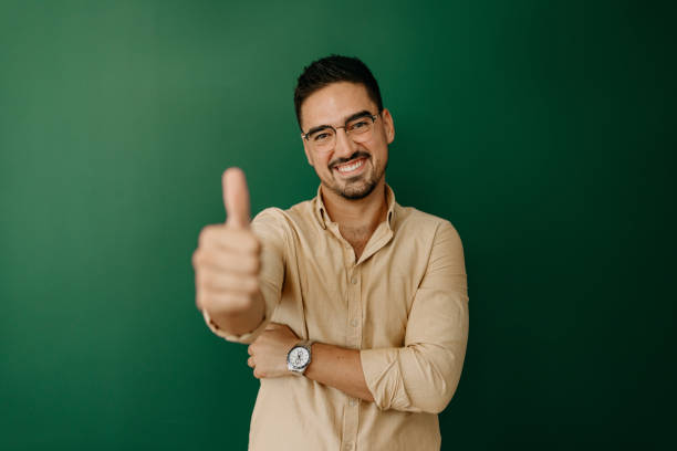 You are OK Handsome man holding thumbs up - studio shot spokesmodel stock pictures, royalty-free photos & images