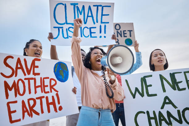 istock Black woman, climate change and megaphone protest with crowd protesting for environment and change. Save earth sign, group activism and angry people shouting on bullhorn to stop planet pollution. 1807918871