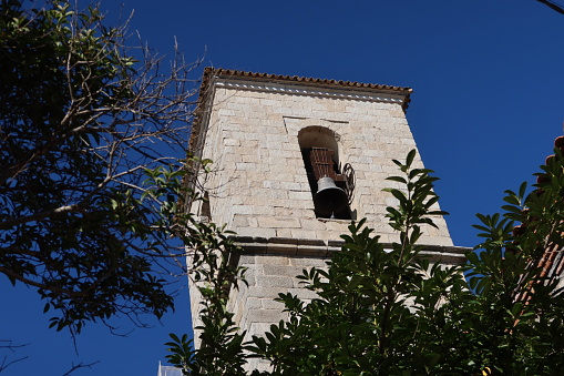 Church of the Assumption, Cadalso de los Vidrios, Madrid, Spain, November 18, 2023: Bell tower of the Parish Church of the Assumption (16th century). Cadalso de los Vidrios, Madrid, Spain