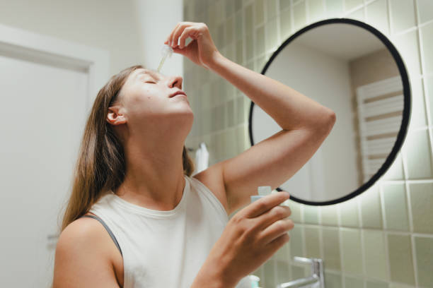 istock Woman Applying On Her Face Doing Acne Treatment in Bathroom 1807924031