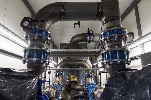 High capacity absorption heat pump during installation. Pump and pipes in foreground(