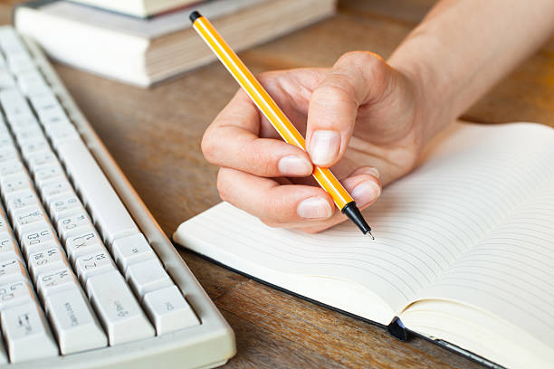 istock Young woman hands writes a pen in notebook 180793789