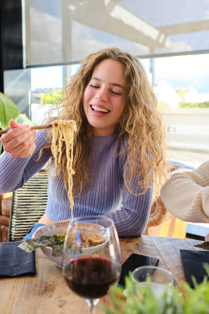 istock Satisfied fair haired woman eating ramen in restaurant 1807941507