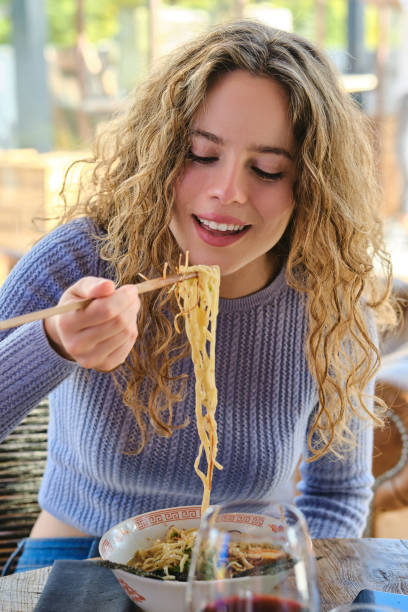 istock Young female enjoying delicious ramen in modern restaurant 1807942039
