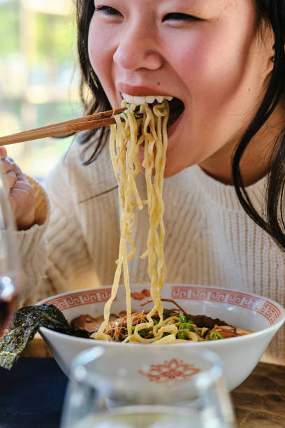 istock Young Asian female eating ramen in restaurant 1807942549