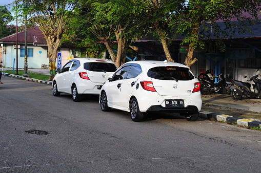 Riau-indonesia, november 21th 2023 : two white car parked on the street