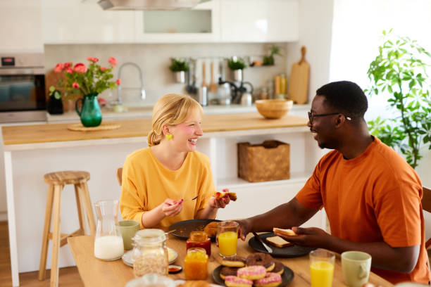 istock Multiracial couple enjoying breakfast together at home 1807950390