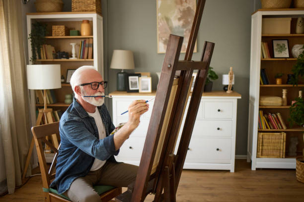 istock Elderly man painting on a canvas at home 1807958891
