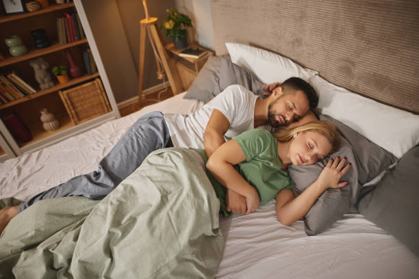 istock Couple sleeping embraced in bed 1807958940