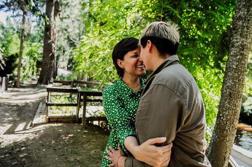 Lesbian couple face to face at natural parkland