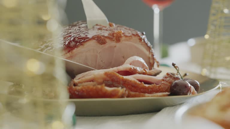 Close-Up of Woman slicing Christmas ham or gammon