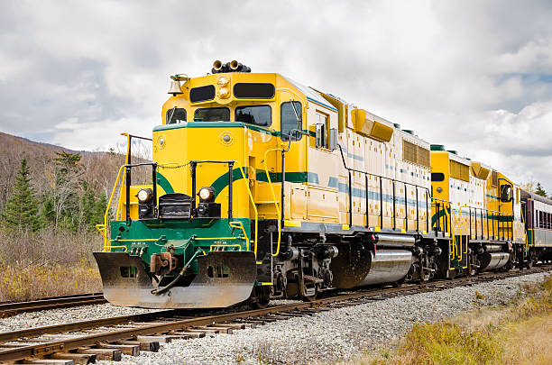 Diesel locomotive in yellow and green Colourful Diesel Locomotive and Cloudy Sky white mountains new hampshire stock pictures, royalty-free photos & images