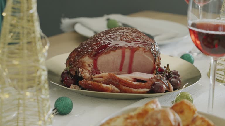 Sliced Christmas Gammon or Ham with Cherry sauce being poured over