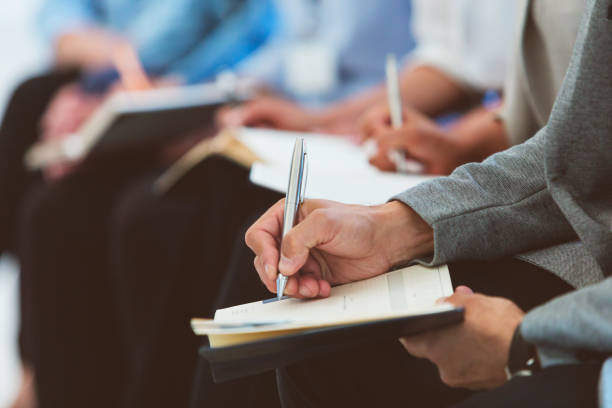 istock People writing in notepads during business conference 1807984492