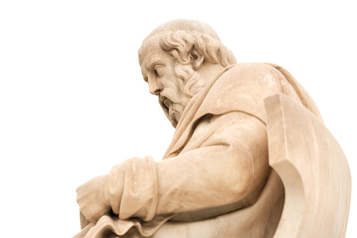 dA side view close up of the marble statue of the classical Greek philosopher Plato, located outside the Academy of Athens, seen against a white background.\n\nThe statue was completed in 1885 by Leonidas Drosis.