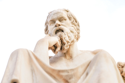 Close-up front view of the classical Greek philosopher Socrates, located at the Academy of Athens, against a white background.\n\nThe statue was completed in 1885 by Leonidas Drosis.