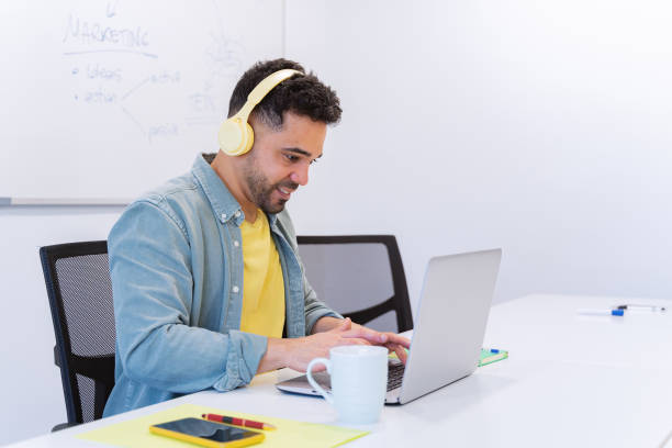 istock Businessman with headphones while working on a laptop in the office. 1807995436