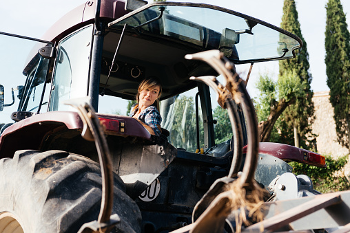 Little girl sitting in a tractor seat during her grandparents visit in a village in Serbia