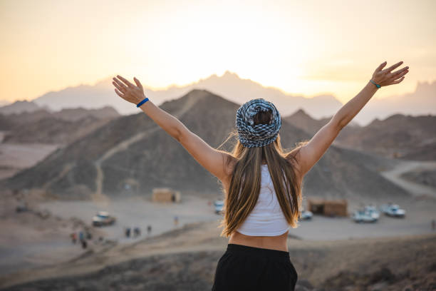 Beautiful young blonde woman running and having fun in the desert while on vacation in Egypt.