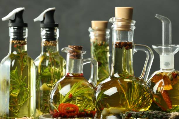 istock Cooking oil with different spices and herbs in bottles against grey background 1808024182
