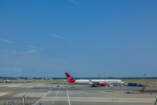 USA. New York. 10.27.2023. Beautiful view of parked Virgin Atlantic airplane at New York's airport against backdrop of blue sky.