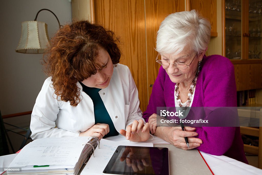 雌介護士が、書類の老人女性 - 介護士のロイヤリティフリーストックフォト
