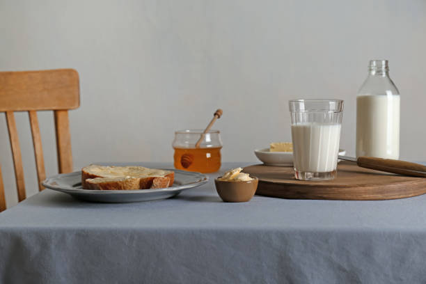 istock Milk, honey and bread served for breakfast on grey table indoors 1808055422