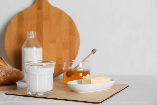 istock Jar with honey, milk, butter and bread served for breakfast on table. Space for text 1808055955
