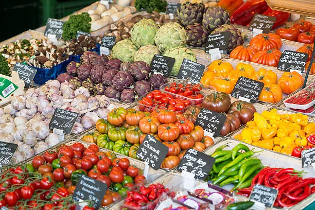 Vegetable (artichoke, pepper, tomato, garlic) on market stall on the famous Munich Viktualienmarkt.