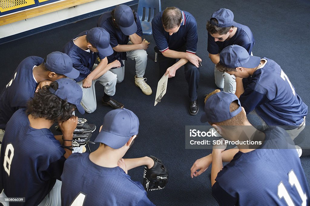 baseball lycéen joueurs prier ensemble de vestiaire - Photo de Prier libre de droits