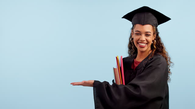 Graduate, woman and student pointing to space in education, college or university presentation in studio. Face of african person of graduation information, palm and learning offer on blue background