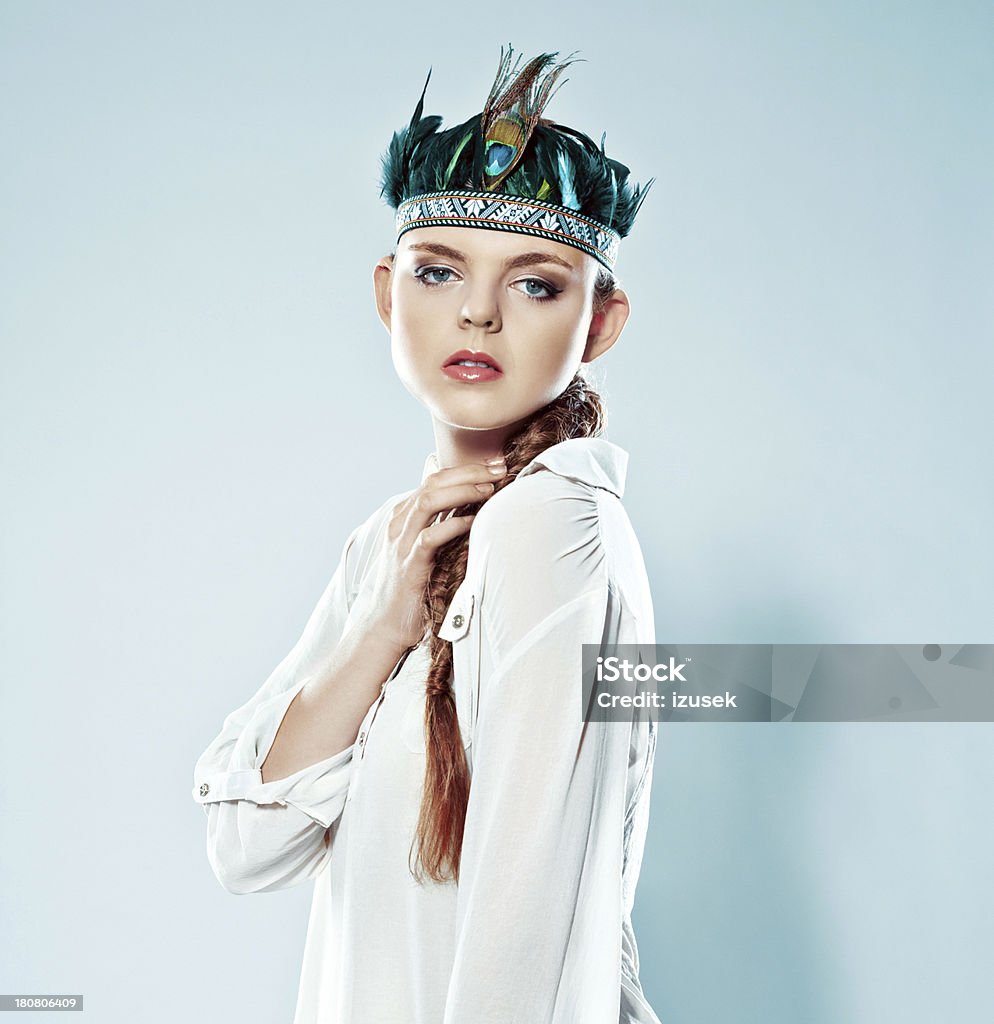 Woman wearing feather Fashion portrait of young adult woman wearing feather headdress. Studio shot. 20-24 Years Stock Photo