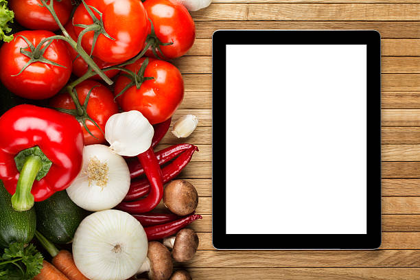 istock Digital tablet on wooden surface with vegetables 180806504