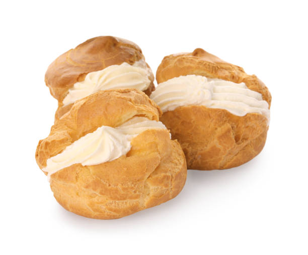 istock Delicious profiteroles with cream filling on white background 1808065593