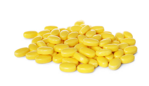 istock Tasty yellow dragee candies on white background 1808066364